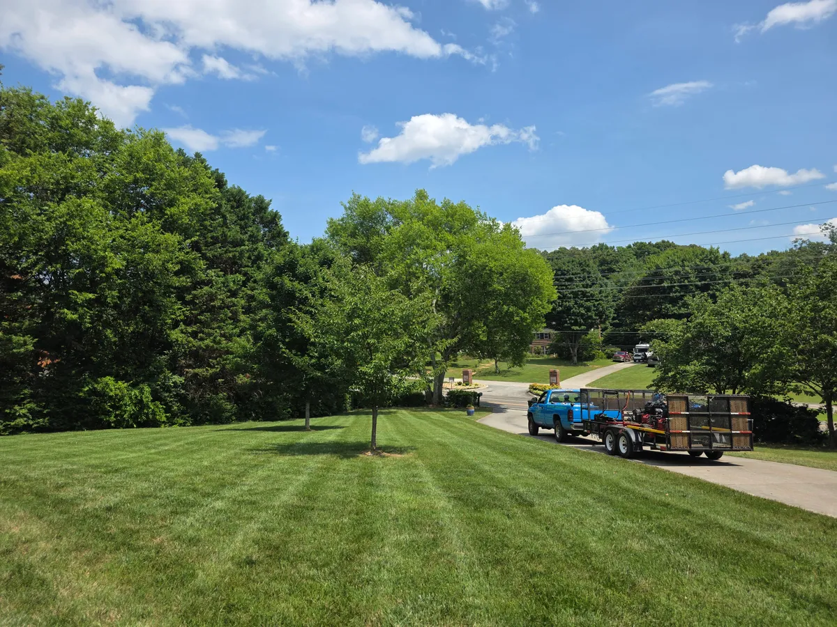 St. John Lawn Care truck parked beside a freshly mowed yard