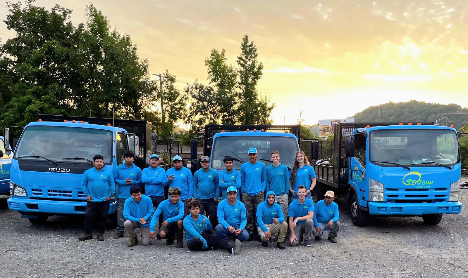 The St. John Lawn Care crew in front of the company trucks
